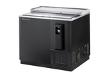 A commercial bottle cooler with a stainless steel top, side-mounted refrigeration, a sliding glass lid, built-in bottle opener, and vented section at the bottom right. The unit sits on a solid base for efficient beverage storage and chilling.