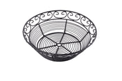 A round, black powder coated metal basket from the Mediterranean Collection Basket line, featuring a decorative swirled pattern around the rim and a circular wire base design, set against a plain white background.