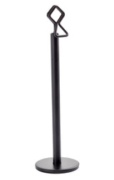 A black powder coated metal stand with a round base and vertical rod, featuring a geometric loop and zigzag-shaped hook. This minimalist, modern number card holder stand by Tablecraft is perfect for stylishly displaying items or signs.