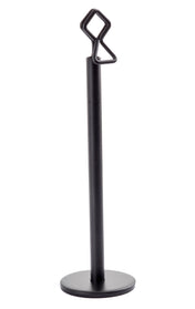 A black powder coated metal stand with a round base and vertical rod, featuring a geometric loop and zigzag-shaped hook. This minimalist, modern number card holder stand by Tablecraft is perfect for stylishly displaying items or signs.