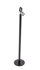 A black metal paper towel holder with a round flat base and a vertical rod, resembling a TableCraft card holder stand. At the top, there is a triangular handle for easy carrying. The plain white background highlights its simple, modern design.