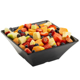 A black Frostone Collection melamine bowl, filled with a colorful mix of bite-sized strawberries, blueberries, pineapple, cantaloupe, honeydew melon, and watermelon. The dishwasher safe bowl sits against a plain white background.