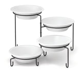 Four white round bowls are displayed on a black powder coated metal four-tiered stand, arranged in a staggered formation. Slip resistant sleeves ensure stability, while the white background highlights the contrasting stands.
