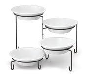 Four white round bowls are displayed on a black powder coated metal four-tiered stand, arranged in a staggered formation. Slip resistant sleeves ensure stability, while the white background highlights the contrasting stands.