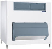 A large commercial ice storage bin with a white body and gray doors. The top section has two rectangular compartments, while the lower section features a wide, slanted door for ice retrieval. An Upright Ice Storage Bin, it stands on metal legs with a “Scotsman” logo visible.