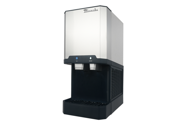 A commercial stainless steel and black ice maker and water dispenser machine with dual spouts, control buttons, drip tray, and brand name “Manitowoc” on top; photographed against a plain light background.