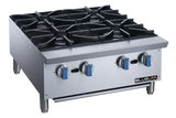 A stainless steel commercial gas stovetop with four burners, heavy cast iron grates, and blue-silver knobs rests on short metal legs. Ideal for countertop use, the clean “BLUELMA” unit stands against a plain background.