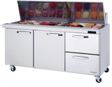 A stainless steel refrigerated prep table with two doors and two drawers on wheels. The top features an open section with containers of sliced vegetables, meats, and cheeses under a raised glass lid. A digital temperature display is on the right side.