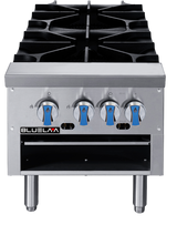 A stainless steel commercial stove with four black cast iron gas burners, four blue and silver control knobs on the front panel, and a lower open shelf. Ideal for any commercial kitchen, the BLUELAA brand name appears on the left side of the panel.