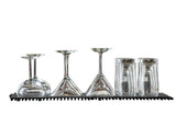 Five clean glasses, including two martini glasses, one wine glass, and two tall tumblers, are placed upside down on a non-slip bar mat against a white background. The clear glassware is neatly aligned in a row and is dishwasher safe.
