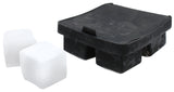A black silicone ice cube tray with square molds is shown, next to two large, perfectly square ice cubes that have been removed from the tray. The flexible, dishwasher safe tray has four compartments and a slightly glossy surface.
