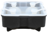 A black and white silicone ice sphere tray with four large round compartments, each sealed with a white cap featuring a looped handle, designed to make spherical ice balls. The tray appears empty and is shown from a slightly low, front-facing angle.