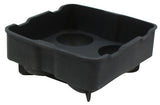 A black, square silicone ice tray with raised edges and four rounded corners. The tray features a slightly tapered shape, three circular indentations in the base, and four short legs or pegs underneath for support. Dishwasher safe for easy cleaning.