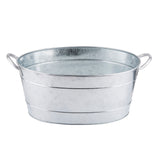 A shiny, oval-shaped TableCraft beverage tub made of galvanized steel with two curved side handles. The tub features a smooth, slightly reflective surface with visible horizontal seams and a simple, industrial design. The interior appears empty and clean.