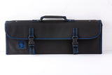 A black rectangular knife case with blue stitching, two front snap-buckle straps, a top handle, and a patch featuring a chef illustration. The background is white, and the case appears closed and empty. Holds 10 knives securely.
