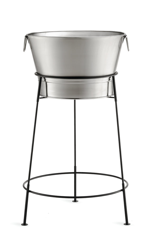A large, round, TableCraft Products stainless steel tub sits on a black, tall, tripod-style metal stand with thin legs and a circular support. The tub has side handles and is perfect as a beverage tub set for holding ice drinks. Background is white.