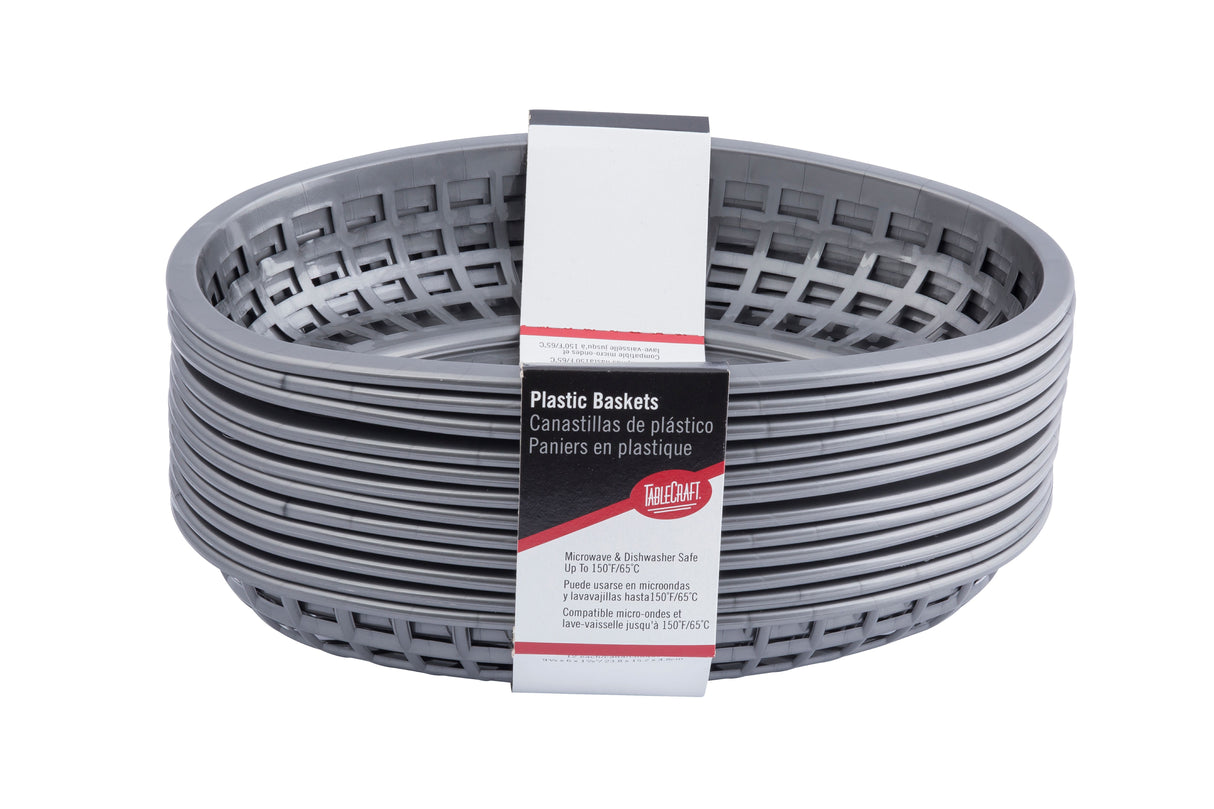 A stack of gunmetal, oval-shaped plastic classic baskets with a grid pattern. A paper label in English, Spanish, and French notes they are heat resistant, microwave and dishwasher safe, and branded by The Great Plate.