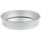 A silver, round aluminum cake pan (9 x 2) with straight sides and a flat bottom is shown on a white background. The empty pan is photographed at a slight angle, showcasing its depth and smooth, reflective surface.