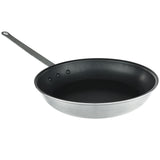 A 14 inch metal fry pan with a black nonstick interior and a long, flat handle. The round, shallow pan is silver on the outside, secured with three rivets. The background is plain and white.