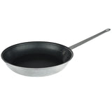 A 14 inch non stick fry pan with a shiny silver metal exterior, black interior, and a long metal handle with a hanging hole, rests on a white background and is angled to display its round shape and depth.