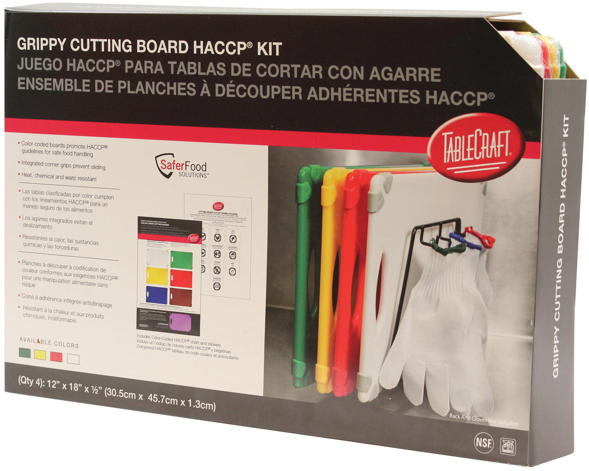 A TableCraft HACCP cutting board kit box is shown. The packaging displays five color-coded, grippy cutting boards with matching tongs and safety gloves. Text in English and Spanish, plus a diagram explains safe use for different food types.