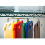 A metal rack with six hooks holds a HACCP Cutting Board Kit in different colors: white, yellow, red, green, blue, and brown. The boards are organized and upright below a wire shelf with a clear plastic container on top.