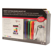 A box displaying the TableCraft Grippy Cutting Board HACCP Kit with six dishwasher safe cutting boards and a white stand. The box details the kit’s components in English, Spanish, and French, showing a photo of the boards arranged in the stand.