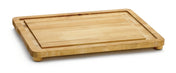 A rectangular wooden carving board with rounded edges and short legs. The board has a groove near the edge to catch liquids, a light wood grain, and non-slip feet. The background is plain white.
