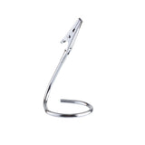 A stainless steel alligator clip is attached to the end of a curved, spiral wire stand. The shiny number card holder coils at the base for stability, with the clip angled upward to hold small items or notes. The background is plain white.