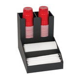 A sleek black countertop condiment organizer holds two stacks of red plastic cups upright, a horizontal stack of white cups, and a compartment with neatly arranged white napkins, all separated into designated sections on a white background.