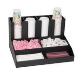 A black condiment organizer holds paper cups, plastic lids, pink and white sweetener packets, dairy creamer packets, white stir sticks, and red straws, neatly separated in compartments for convenient coffee or beverage preparation.