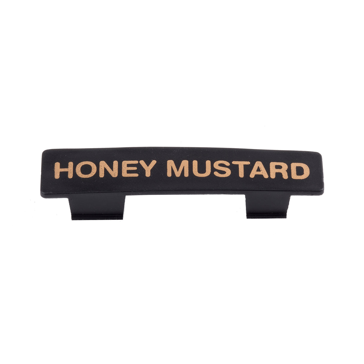 A black rectangular Name Tag label with gold capital letters spelling HONEY MUSTARD. Featuring two small tabs on the bottom for easy attachment to a dispenser or container, this tag is dishwasher safe. The background is plain white.