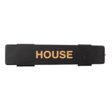 A rectangular black polypropylene name tag with the word HOUSE printed in gold, uppercase letters centered on it. The background is plain white, and the slightly textured nameplate is also dishwasher safe.