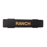 A black rectangular Ranch name tag label with the word RANCH in bold, uppercase, tan letters. Made from dishwasher safe polypropylene, it has clips or tabs on each side and is set against a plain white background.