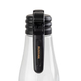 A clear glass bottle with a black flip-top cap is shown against a white background. The word RUSSIAN is printed in gold letters on the cap’s latch, which is closed and positioned vertically down the bottle’s neck. This bottle is dishwasher safe.