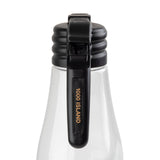 A close-up of a clear plastic bottle with a black flip-top cap labeled "1000 ISLAND" in gold letters. The black handle secures the lid, and a name tag indicates it is dishwasher safe. The background is plain white.
