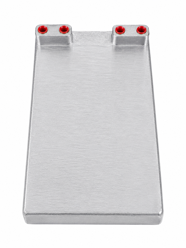 A flat, rectangular cold plate with a smooth surface, featuring four small circular holes lined with red on one end. The plate’s slightly raised edges and plain white background highlight the integrated stainless steel tubing by Micro Matic.