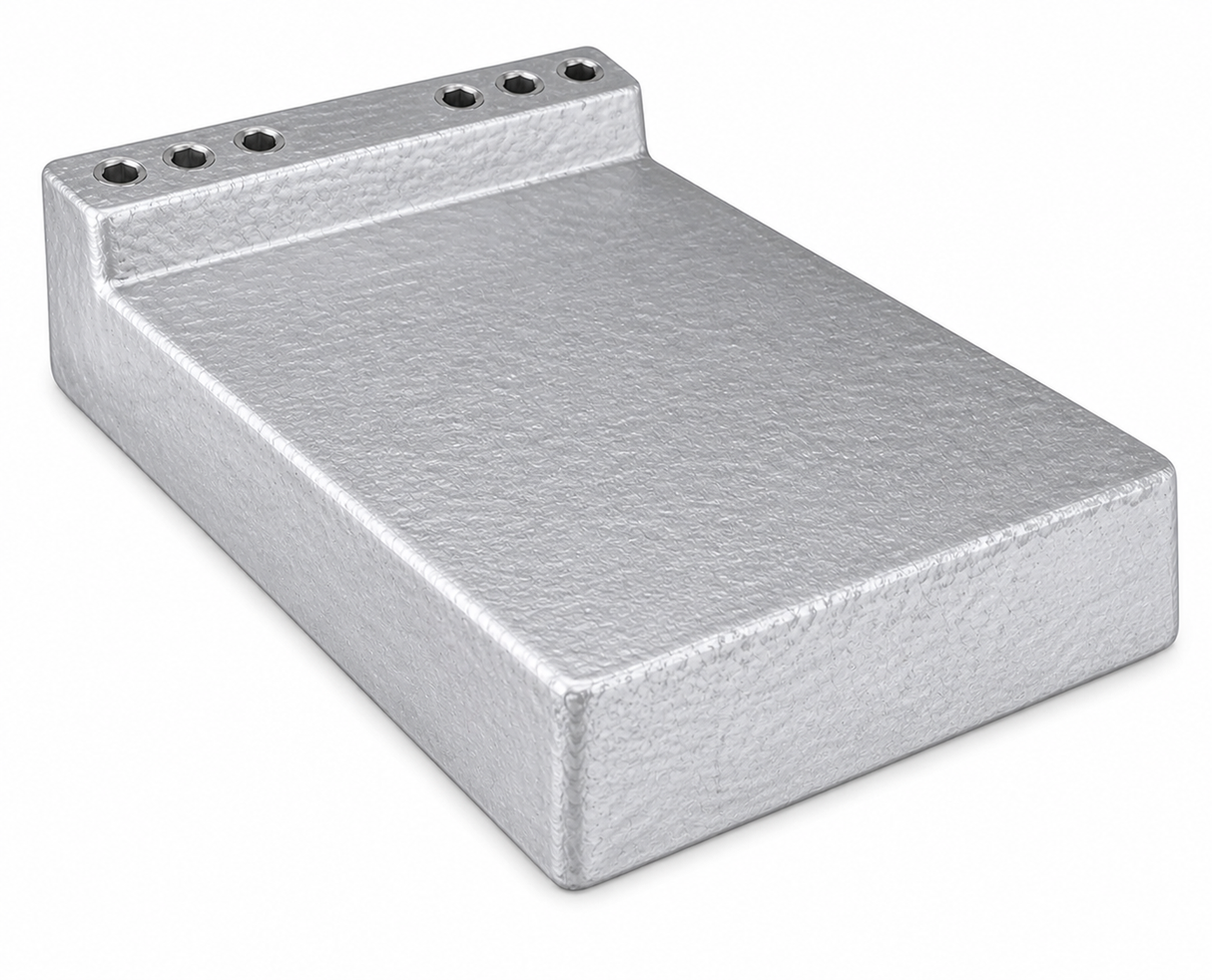 A rectangular, silver metallic cold plate with a textured surface. One end is raised vertically, featuring six evenly spaced circular holes along the top edge. The plain white background highlights its industrial, machined appearance and stainless steel tubing.