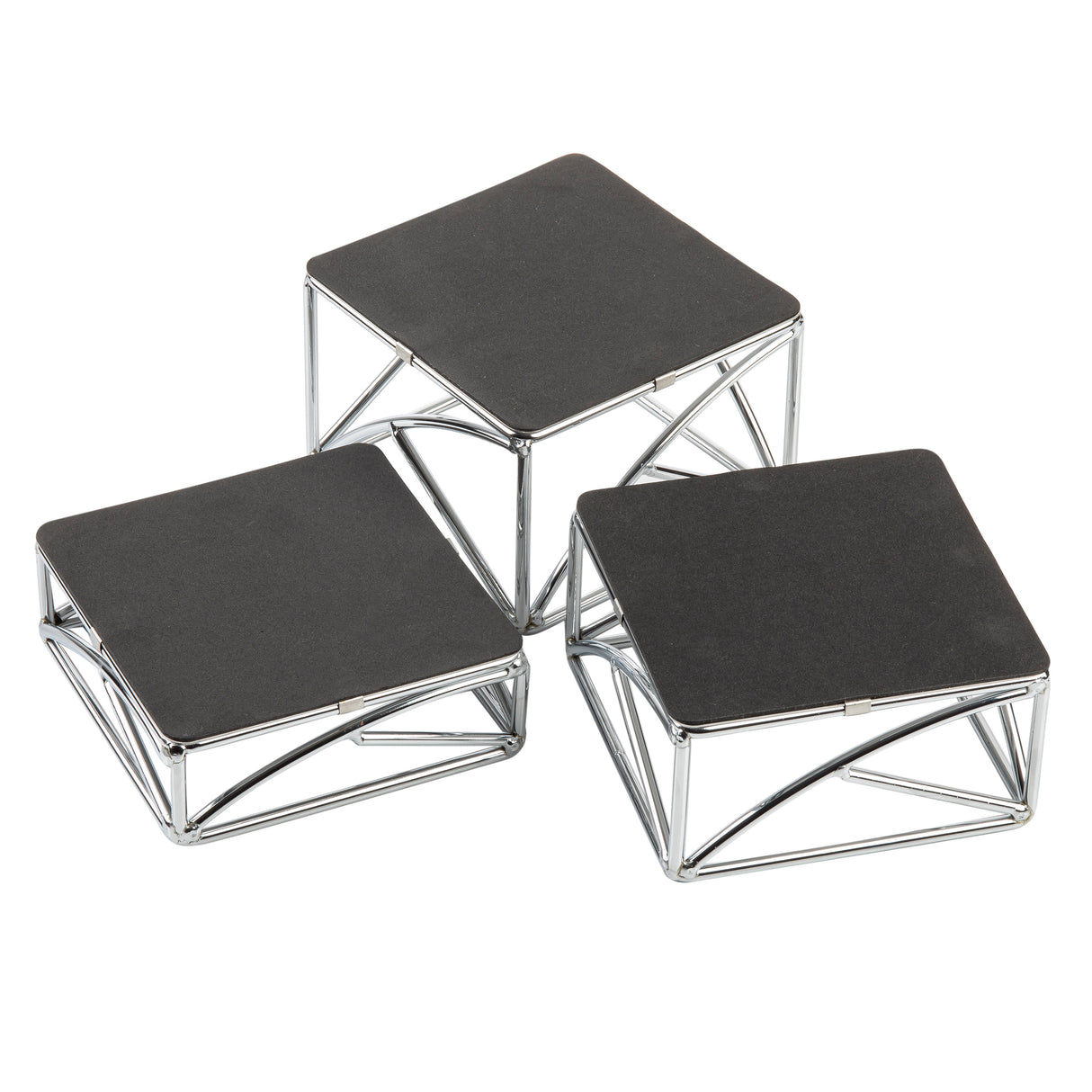 Three modern square display stands with black tops and chrome plated silver metal frames are arranged at different heights. The geometric, angular frames create a striking look as the riser set is grouped closely on a white background.