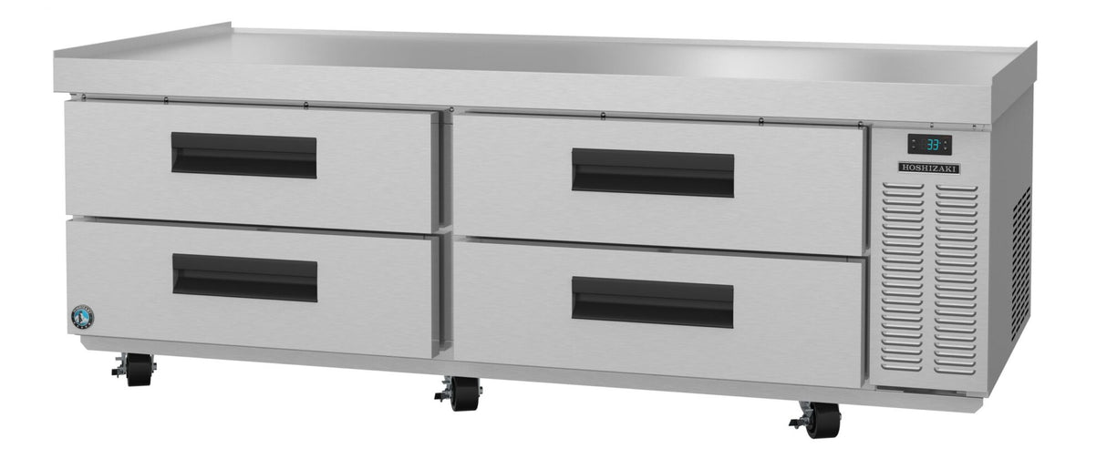 A stainless steel refrigerator with four large pull-out drawers, black handles, digital temperature display, and lockable caster wheels. This low-profile equipment stand has a flat surface, ideal for use as a countertop in commercial kitchens.