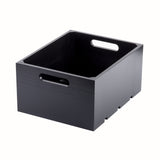 A sleek wood black crate with two cut-out handles on the shorter sides. This display crate features a smooth finish, modern design, and is photographed on a white background to showcase its empty interior.