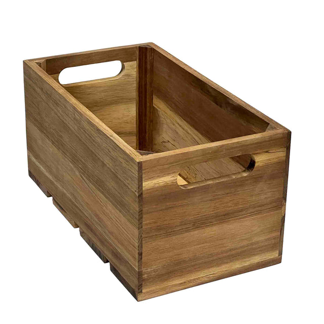 A rectangular Acacia Wood Crate with smooth slats, open top, and cutout handles on each short side. The natural finish highlights the grain patterns. This display crate is empty and positioned at an angle on a white background.