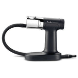 A sleek, black Breville Commercial smoking gun pro with a chrome chamber and flexible black hose rests on a sturdy base. This handheld cold smoke infuser is designed for adding smoky flavors to food and drinks.