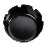 A round, black ceramic ashtray with a smooth surface and evenly spaced grooves for holding cigarettes is shown from above. Similar in style to economy ashtrays, it sits on a white background, making its features clearly visible.