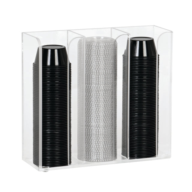 A clear acrylic countertop organizer holds three vertical stacks of disposable cups: two stacks of black plastic cups on the left and right, and one stack of translucent, textured plastic cups in the center. The holder is rectangular with open top and front.