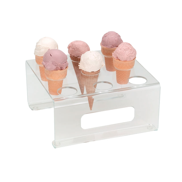 Six ice cream cones with pink and white scoops are displayed upright in an acrylic clear ice cream cone holder from Dispense-Rite, featuring six circular holes and a horizontal slot, on a white background.