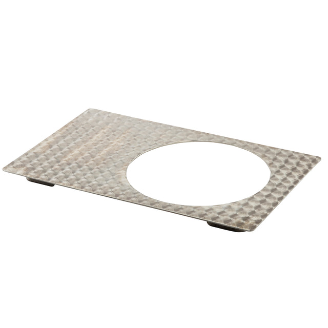 A rectangular stainless steel plate with a textured, dimpled surface and a large circular cutout in the center. Elevated at the corners with small black feet, this hot food template offers an industrial and utilitarian look. Dishwasher safe for easy cleanup.