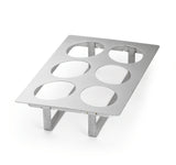 A full size stainless steel rack with six large circular cutouts and four supporting legs, designed to hold items such as jars or cups upright. The smooth, reflective cold food template is rectangular and elevated from the surface.