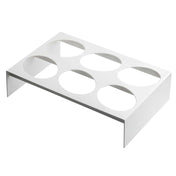 A white, rectangular TableCraft rack made of nylon coated cast aluminum features six large circular cutouts in two rows of three. The short vertical sides elevate it above the ground, making it ideal as a dressing template or for holding round containers.