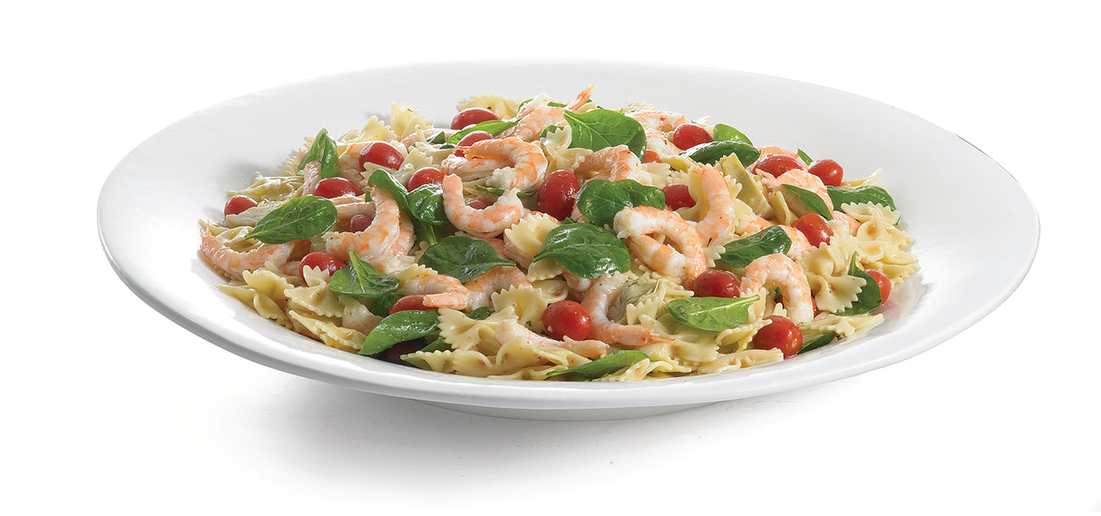 A white cast aluminum platter holds bowtie pasta mixed with shrimp, fresh spinach, and cherry tomatoes, all lightly tossed and garnished, set against a white background for ideal cold holding.